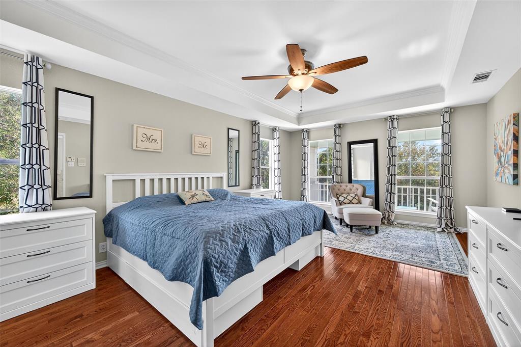 10312 Arvin Hill Road Aubrey, TX 76227 - Photo 25 of 40 a spacious bedroom with a large bed and a chandelier