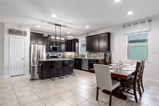 a kitchen with stainless steel appliances granite countertop a refrigerator a stove a sink and a microwave