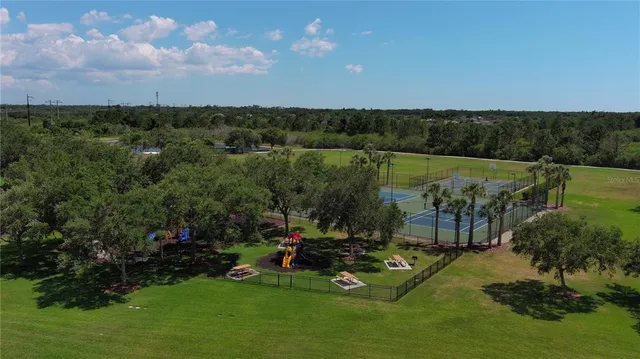 an aerial view of a tennis ground and a yard