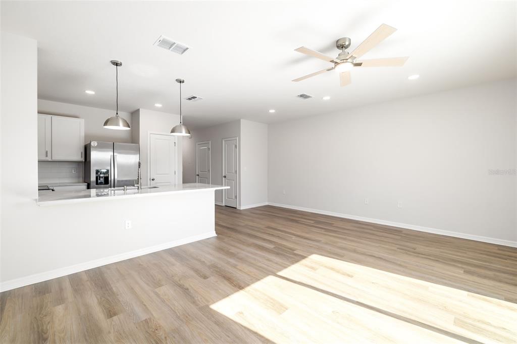 17436 Haysack Terrace Bradenton, FL 34211 - Photo 7 of 53 a view of a kitchen with kitchen island a sink wooden floor and a large window