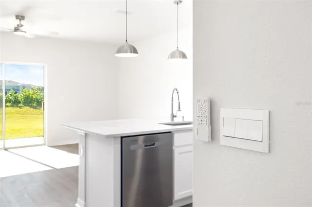 an empty room with windows and fan