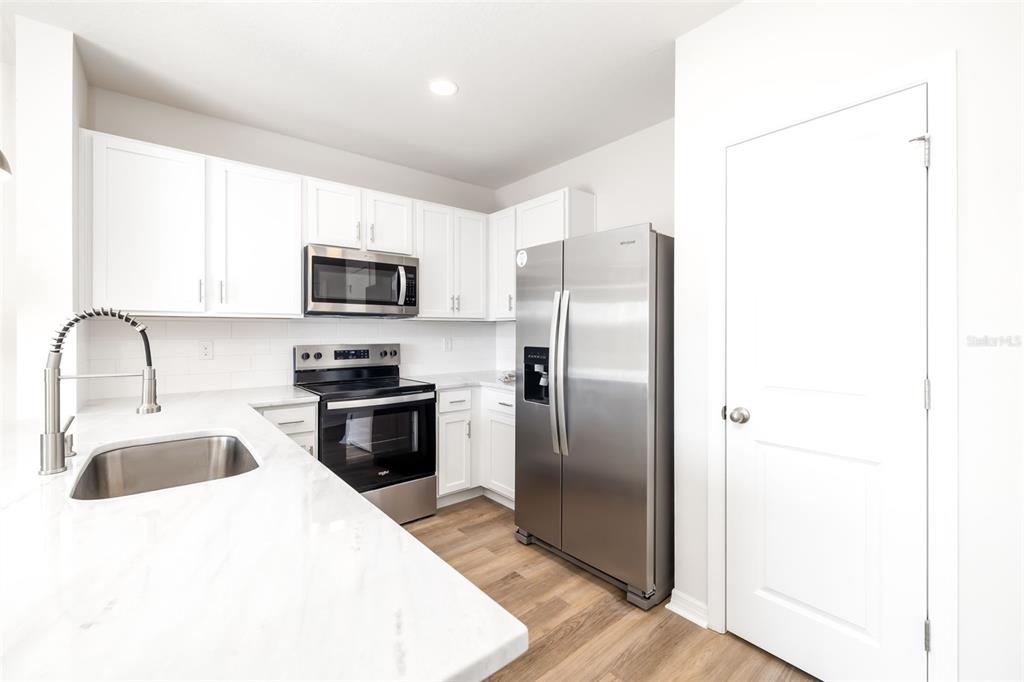 17436 Haysack Terrace Bradenton, FL 34211 - Photo 10 of 53 a kitchen with stainless steel appliances granite countertop a refrigerator a sink a stove and microwave