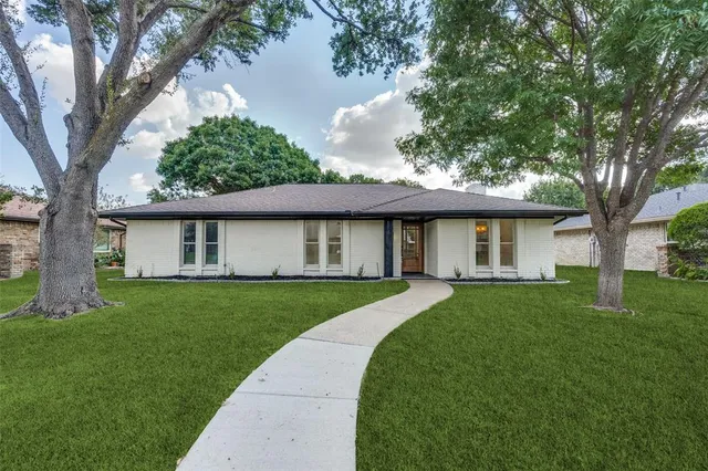 a view of a yard in front of house with a large tree