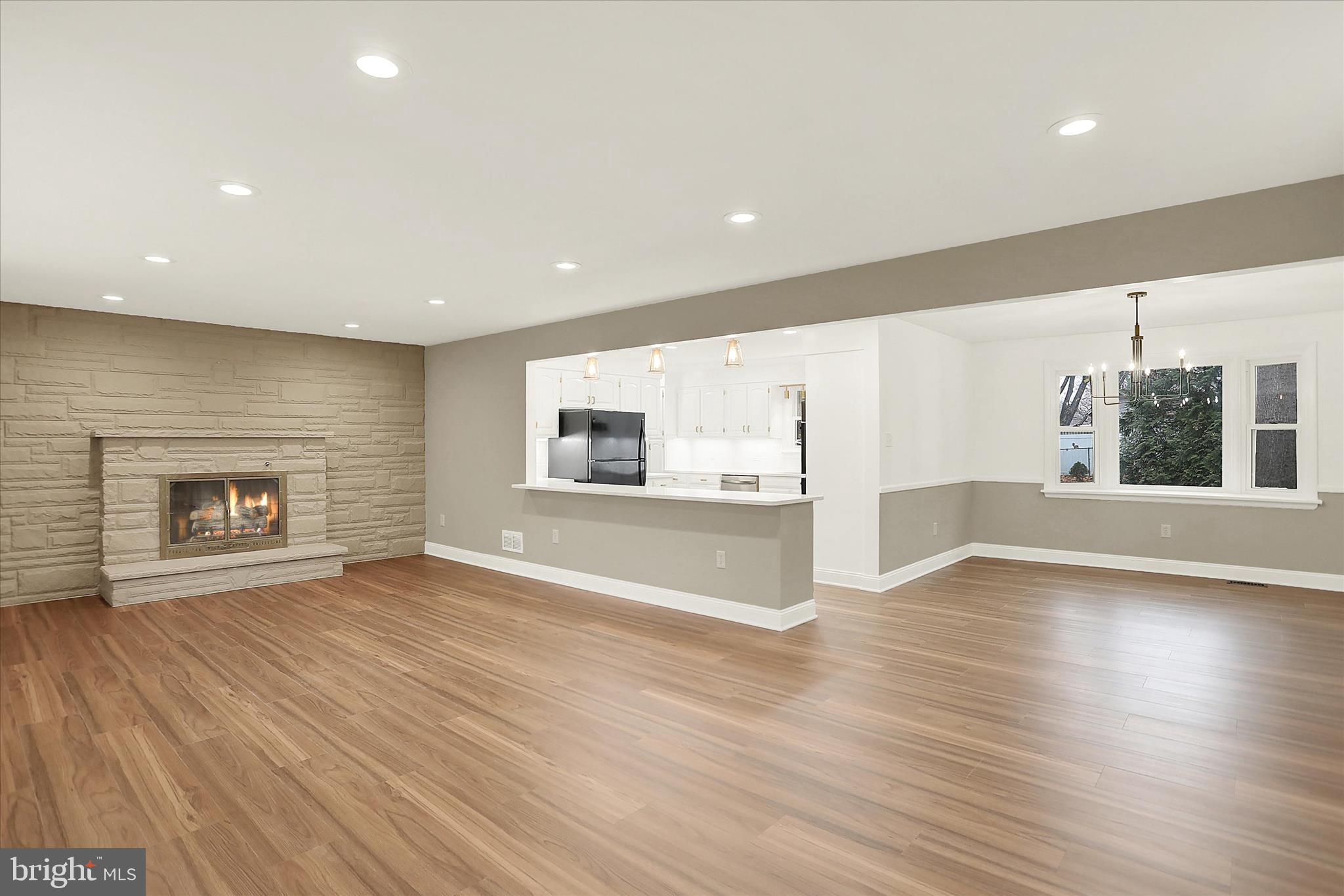1612 Elbridge Road Harrisburg, PA 17112 - Photo 13 of 39 an empty room with wooden floor fireplace and windows