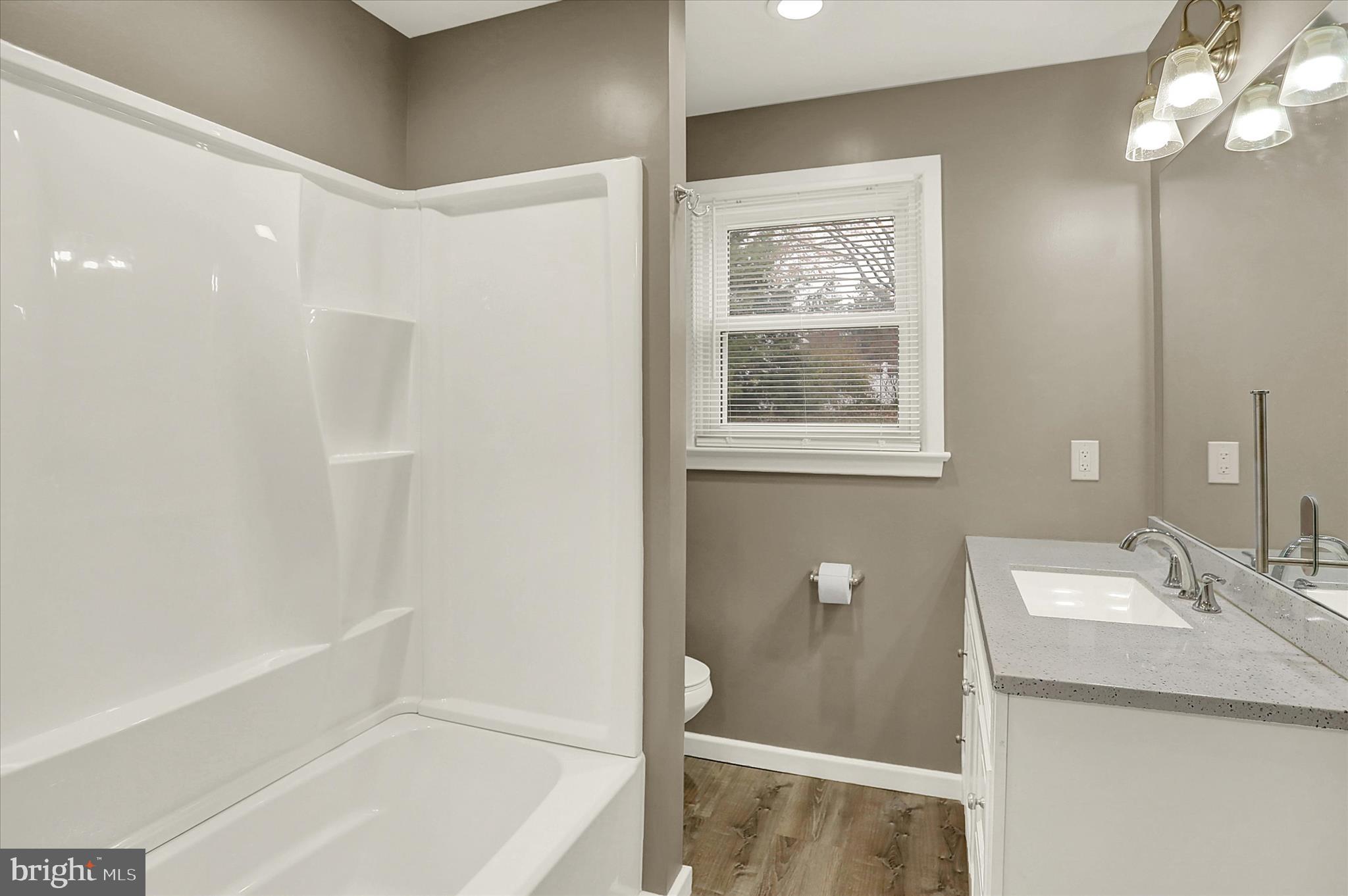 1612 Elbridge Road Harrisburg, PA 17112 - Photo 19 of 39 a bathroom with a bathtub a shower a sink and a window