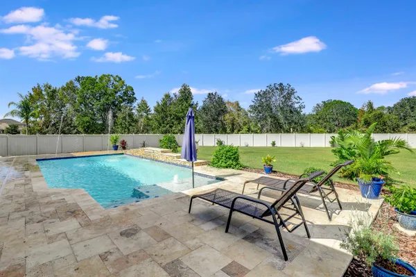 a kitchen with stainless steel appliances kitchen island granite countertop a sink a stove a dining table and chairs