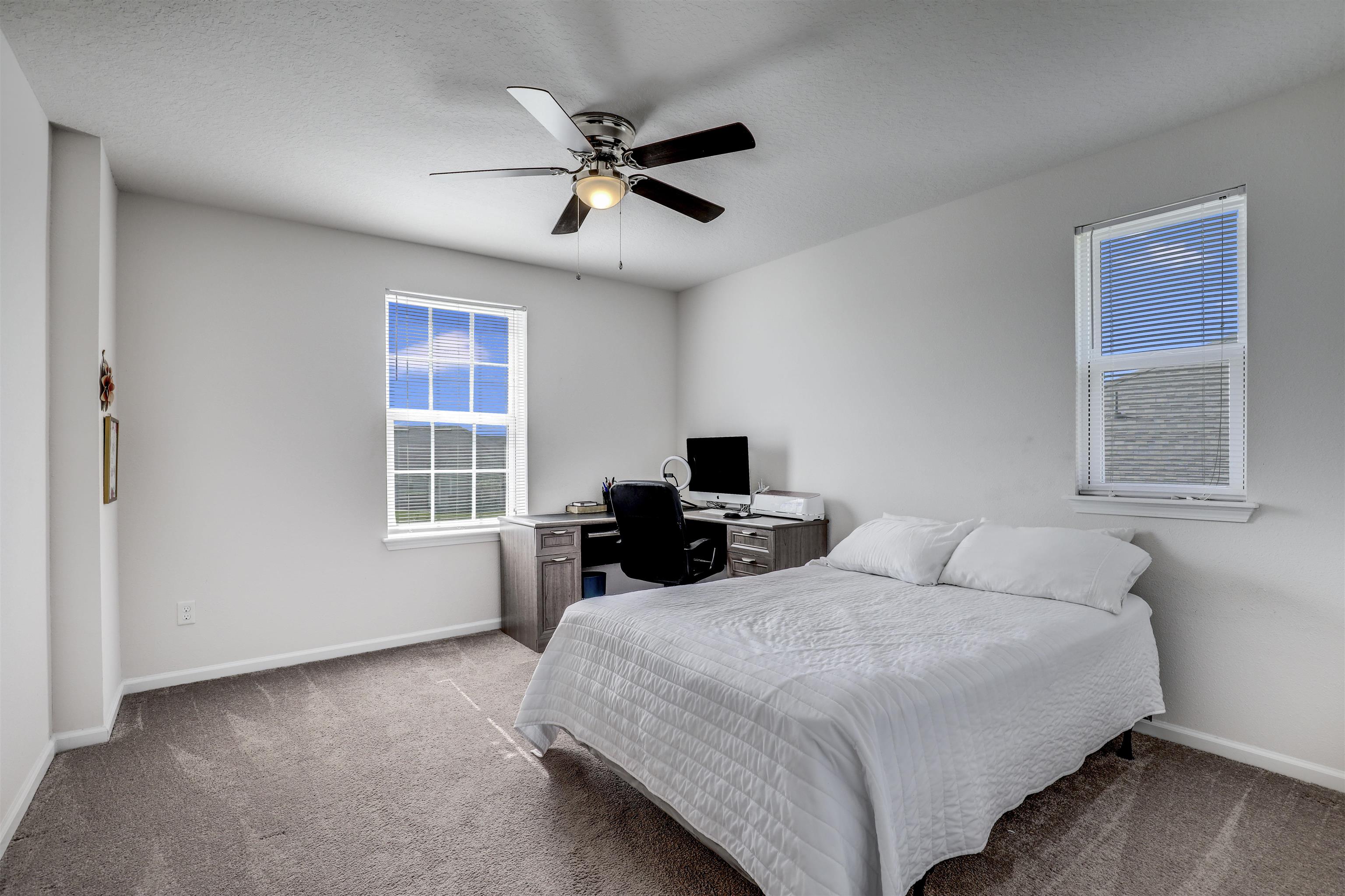 93 Firefly Trace St. Augustine, FL 32092 - Photo 38 of 76 a bedroom with a bed a chandelier and a window