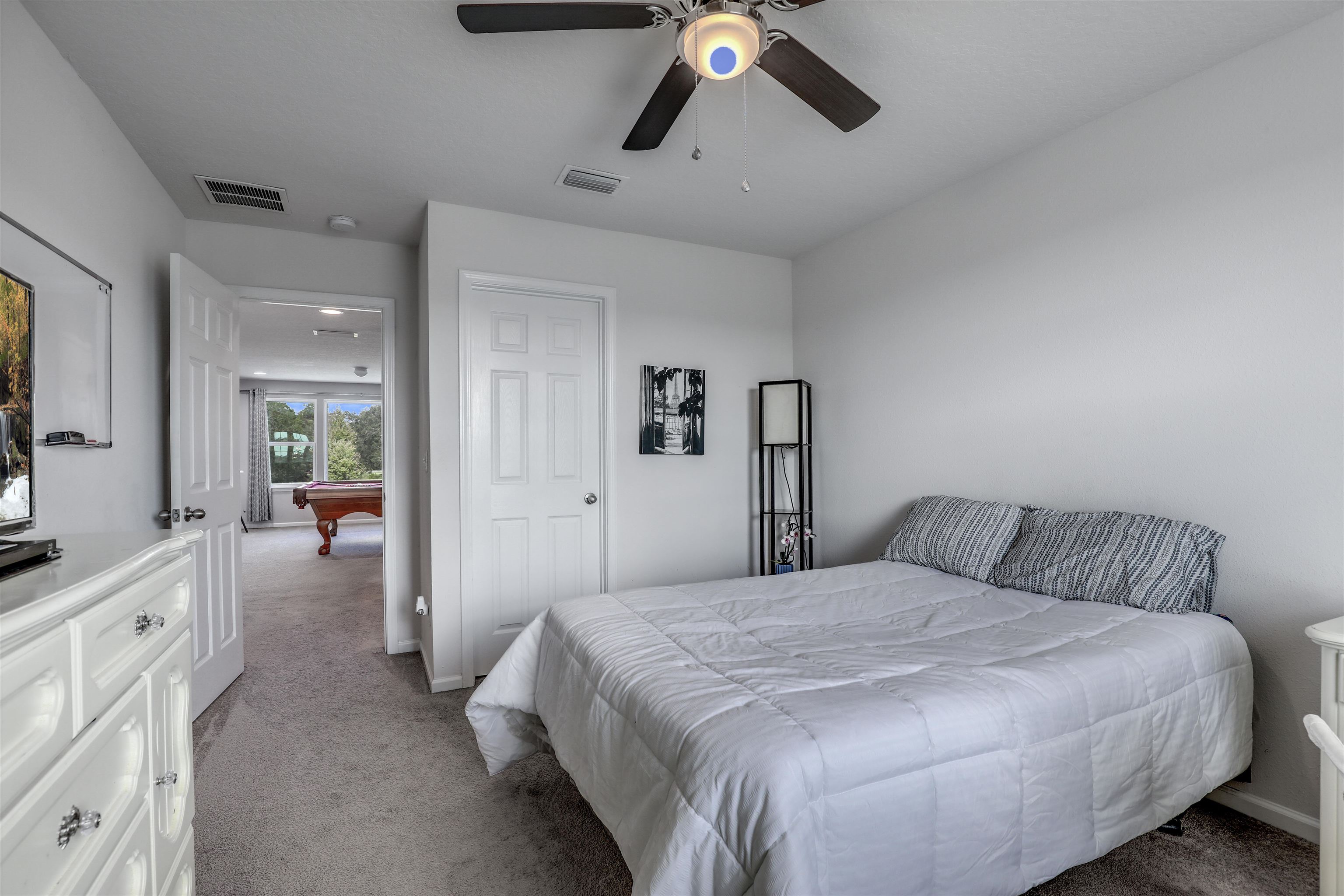 93 Firefly Trace St. Augustine, FL 32092 - Photo 45 of 76 a bedroom with a bed and a chandelier