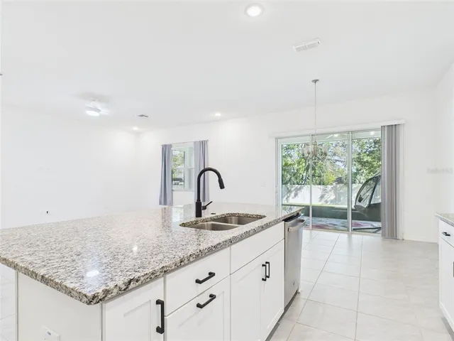 a kitchen with granite countertop a sink and white cabinets