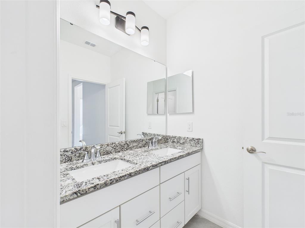 2033 Emerald Springs Drive Apopka, FL 32712 - Photo 23 of 49 a bathroom with a granite countertop sink and a mirror
