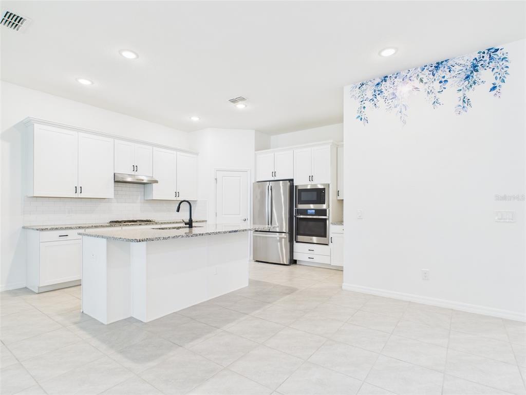 2033 Emerald Springs Drive Apopka, FL 32712 - Photo 6 of 49 a kitchen with stainless steel appliances a refrigerator and a stove top oven