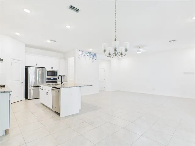 a kitchen with granite countertop a sink stove and refrigerator