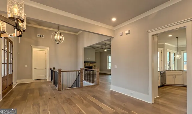 a view of a kitchen with granite countertop a stove a sink and dishwasher with wooden floor