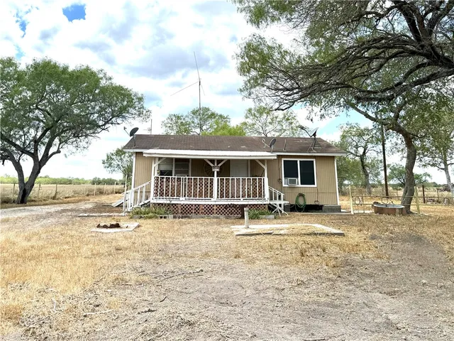 a front view of a house with a garden and trees