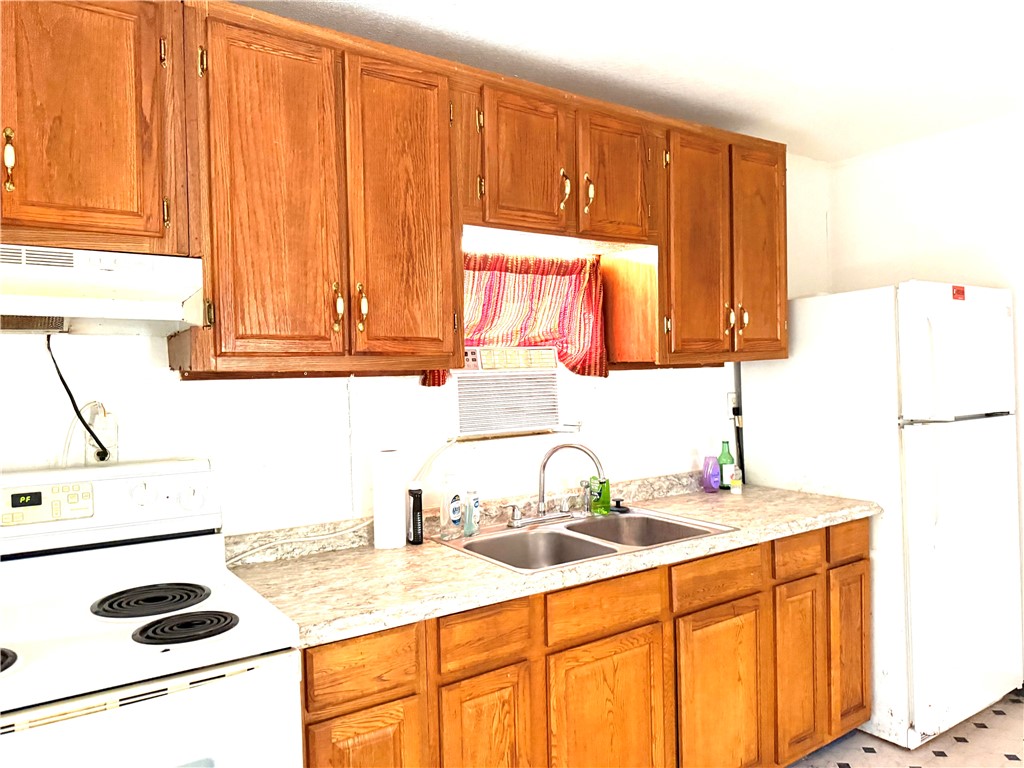 147 County Road 153 Alice, TX 78332 - Photo 14 of 23 a kitchen with a sink and a refrigerator