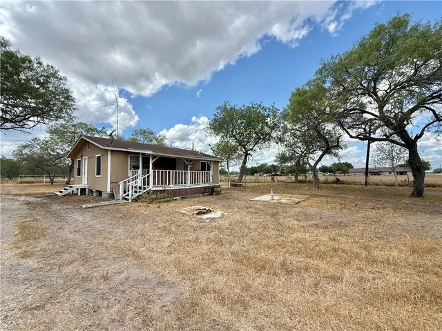 a front view of house with yard space and trees around