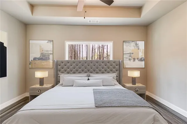 a bedroom with a large bed and wooden floor