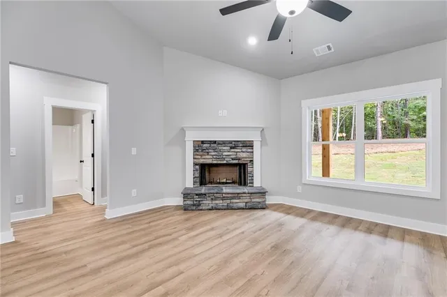 a living room with a fireplace and wooden floor