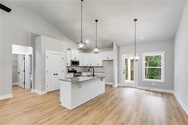 a kitchen with stainless steel appliances granite countertop a stove a refrigerator and a wooden floors
