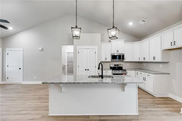 a kitchen with stainless steel appliances granite countertop a sink a stove and a refrigerator