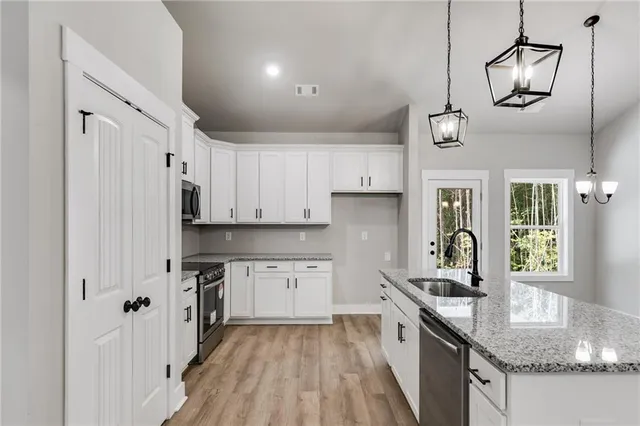 a kitchen with stainless steel appliances granite countertop a sink stove and refrigerator