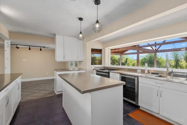 a kitchen with a sink a stove a refrigerator and white cabinets