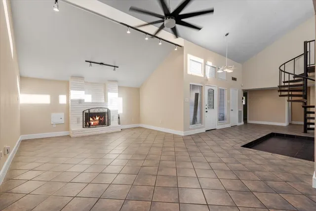a view of an empty room with a fireplace and a window