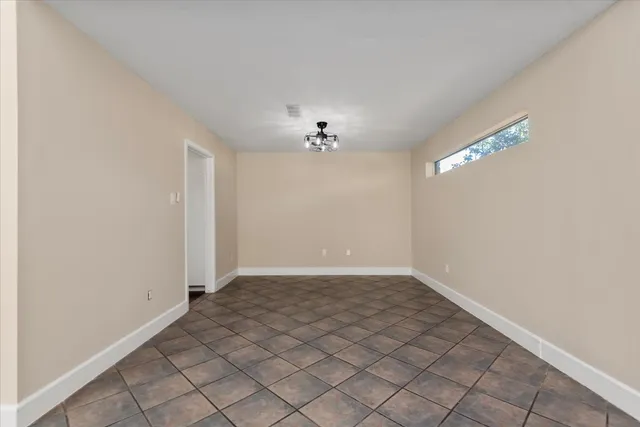 a view of a room with a hanging light and hardwood