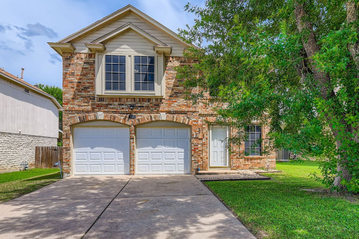 516 Broken Feather Trail Pflugerville, TX 78660 - Photo 1 of 1 View of front facade featuring driveway, a front lawn, brick siding, and a garage