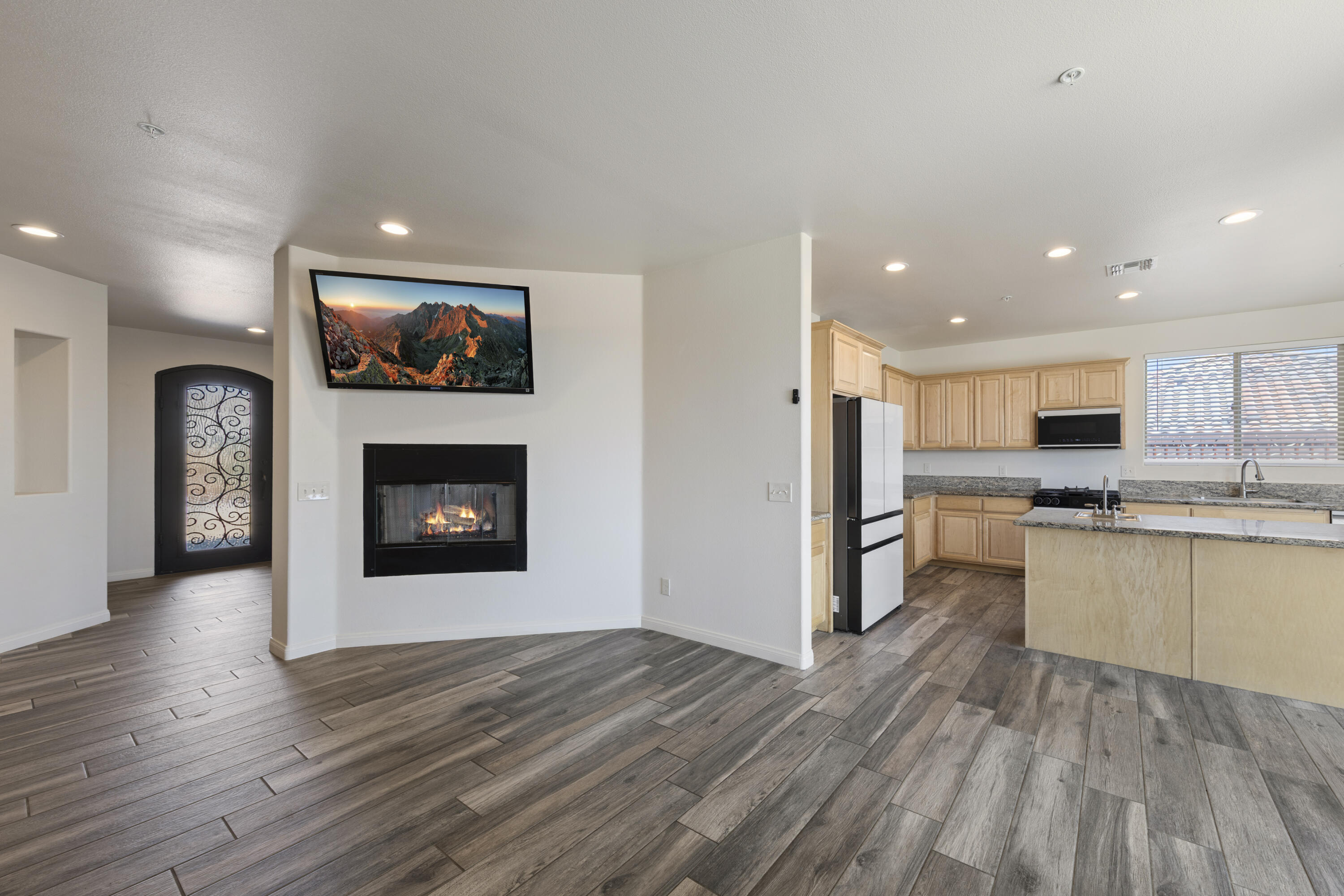 8680 Monument View Drive Yucca Valley, CA 92284 - Photo 3 of 51 a open kitchen with stainless steel appliances kitchen island granite countertop a refrigerator stove top oven and sink with wooden floor