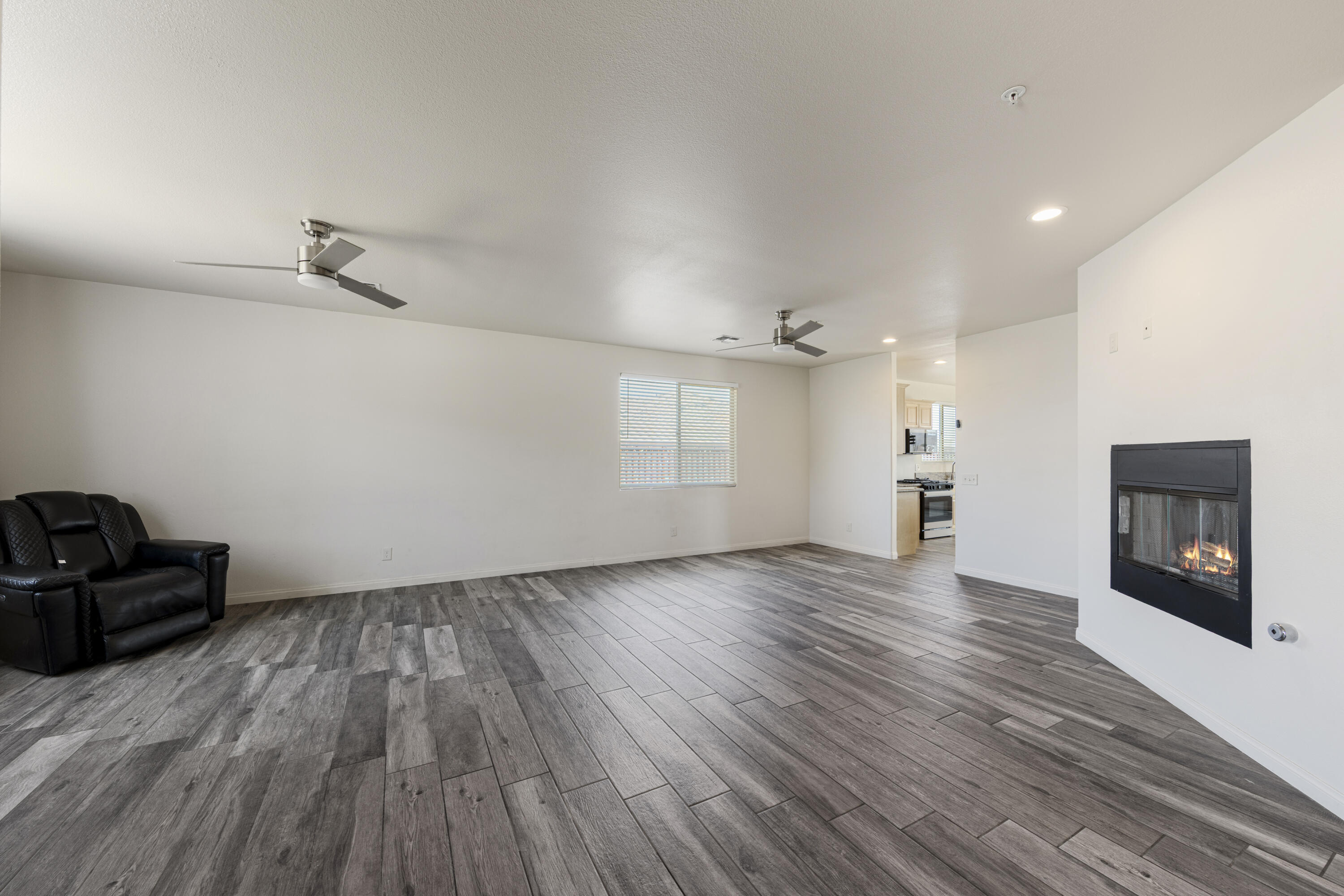 8680 Monument View Drive Yucca Valley, CA 92284 - Photo 6 of 51 a view of a livingroom with wooden floor and a ceiling fan