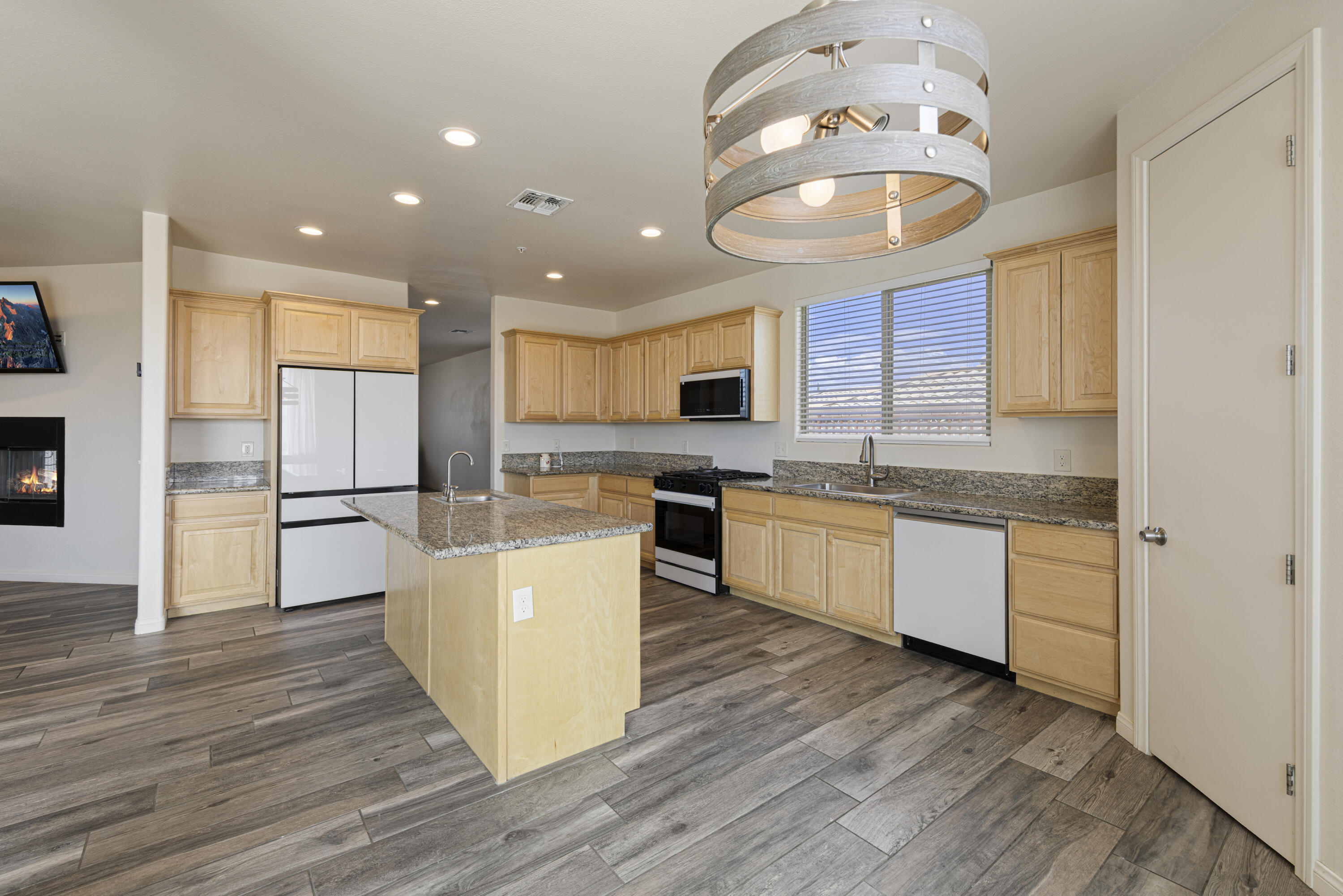 8680 Monument View Drive Yucca Valley, CA 92284 - Photo 8 of 51 a large kitchen with stainless steel appliances granite countertop a stove a sink dishwasher and a refrigerator with wooden floor