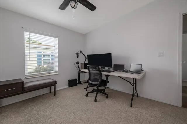 a view of a workspace with furniture and a window