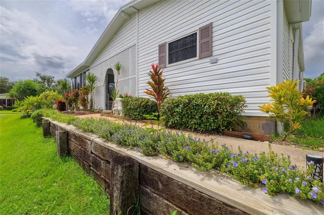 a front view of house and yard with beautiful flowers