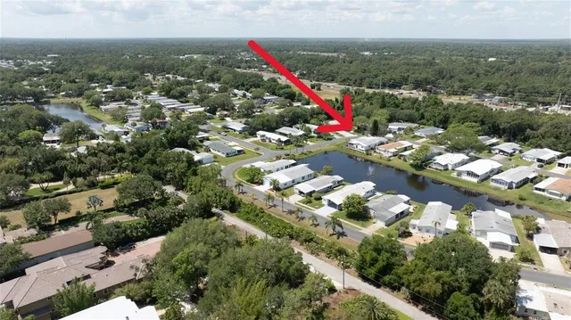 an aerial view of residential houses with outdoor space and trees