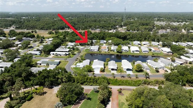 an aerial view of residential houses with outdoor space and lake view