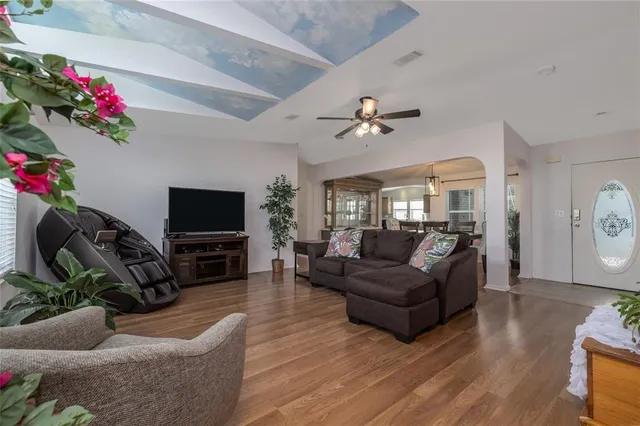 a living room with furniture a flat screen tv and a potted plant