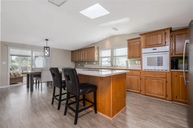 a kitchen with granite countertop a table chairs stove and cabinets