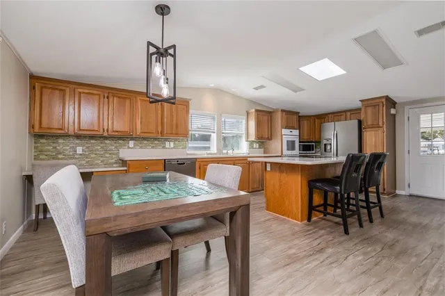 a kitchen with a table chairs refrigerator and cabinets