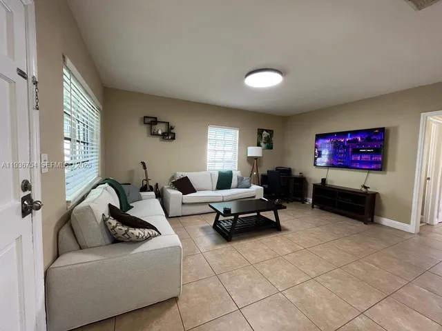 a living room with furniture a rug and white walls