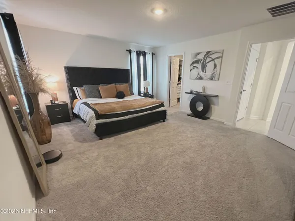 a bedroom with a bed and a refrigerator