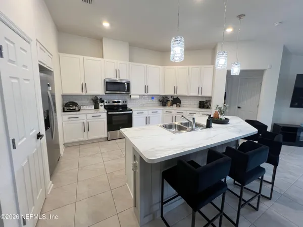 a kitchen with a sink a microwave a refrigerator and cabinets