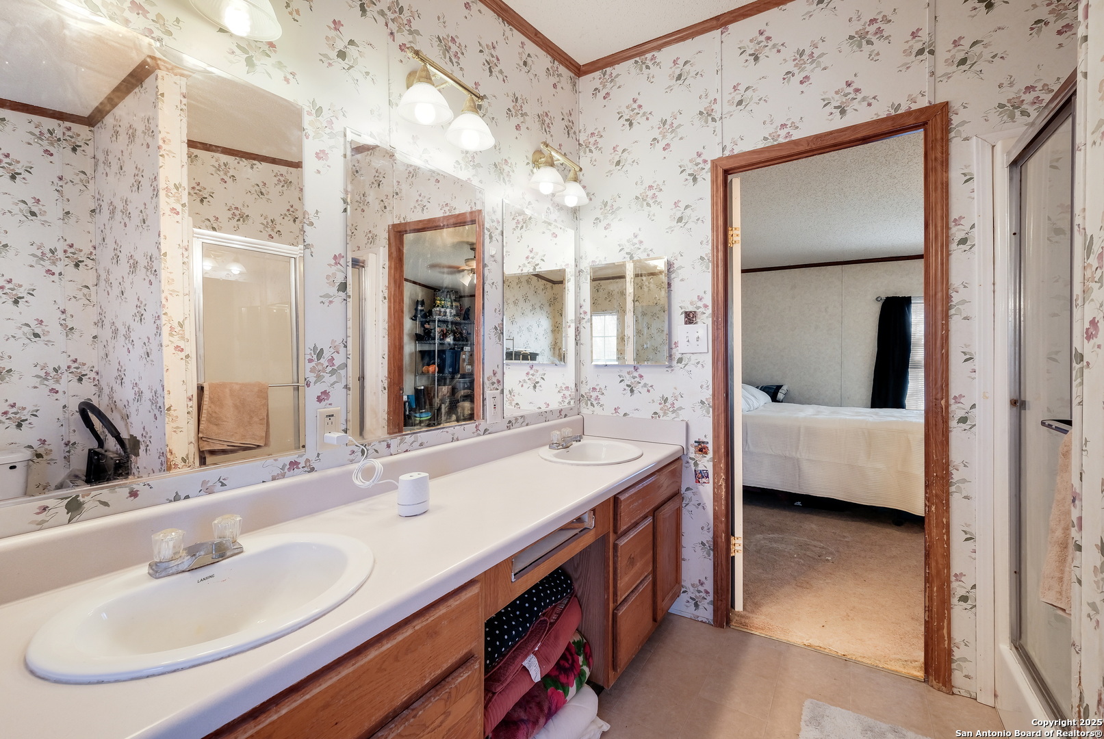 104 Kickapoo Trail Seguin, TX 78155 - Photo 18 of 21 a en suite bathroom with a double vanity sink a large mirror and shower