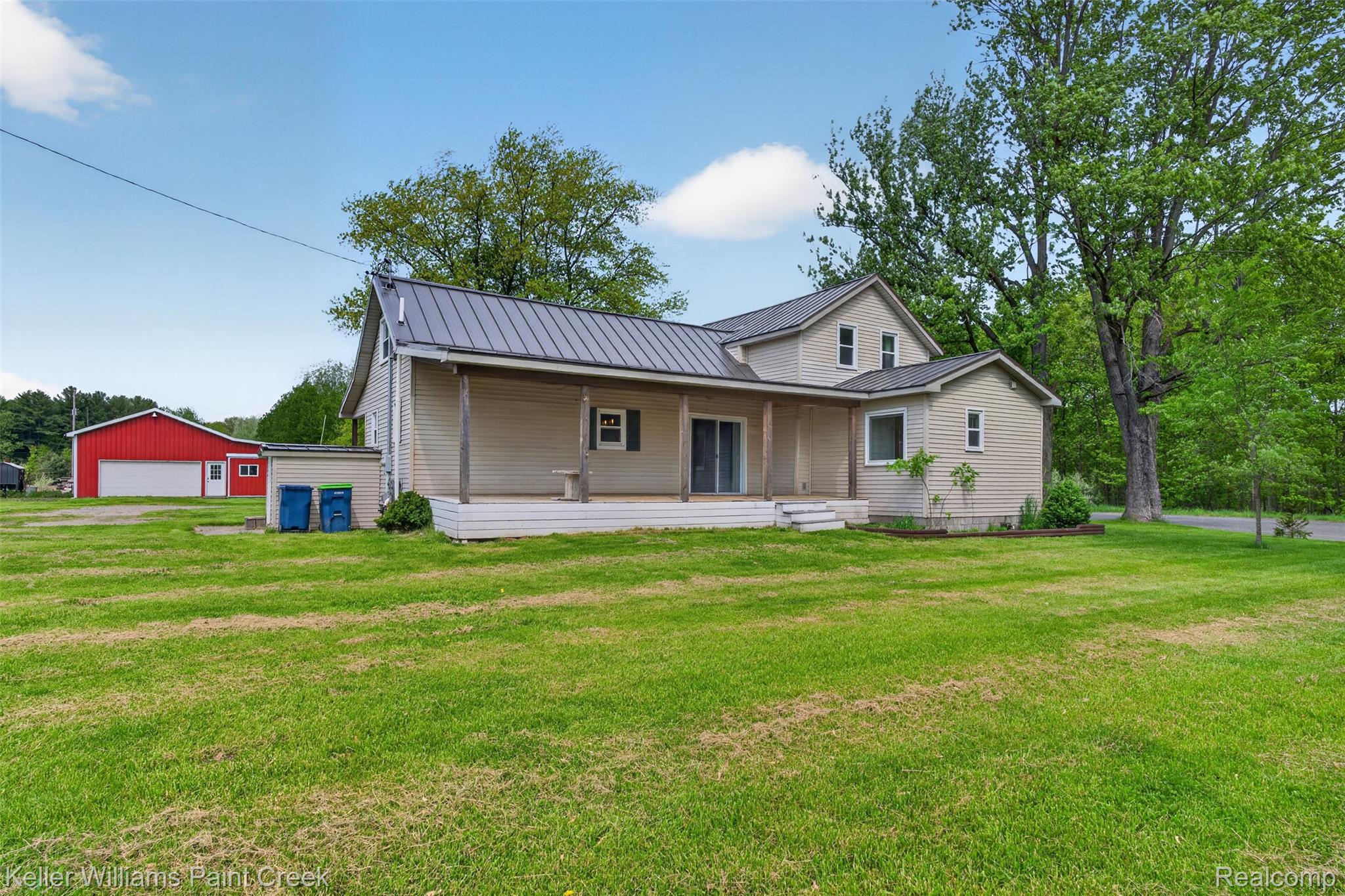 18125 Nelson Road St. Charles, MI 48655 - Photo 41 of 63 Back of house with a porch, a detached garage, an outdoor structure, and a lawn