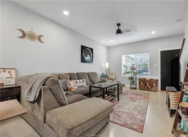 a living room with furniture ceiling fan and a window