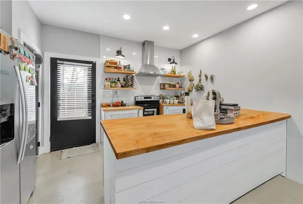 a kitchen with stainless steel appliances granite countertop a refrigerator and a stove top oven