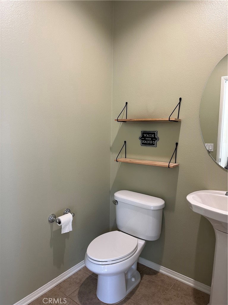 20323 Livorno Way Porter Ranch, CA 91326 - Photo 9 of 14 a white toilet sitting next to a bathroom sink and a mirror