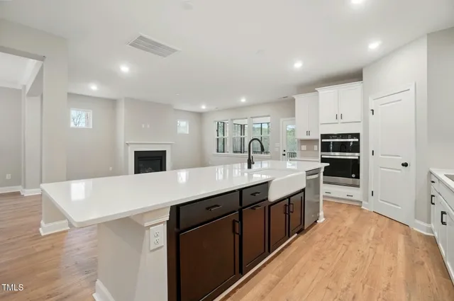 a large kitchen with stainless steel appliances a sink dishwasher stove top oven and refrigerator