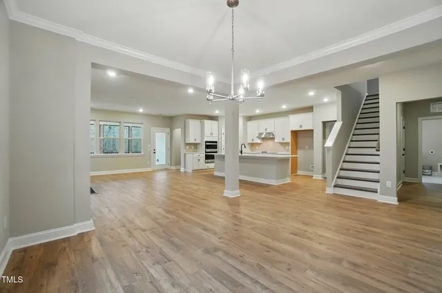 a view of a room with wooden floor and kitchen