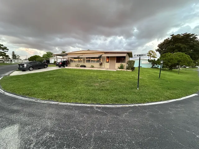 a view of a big house in a big yard with large trees